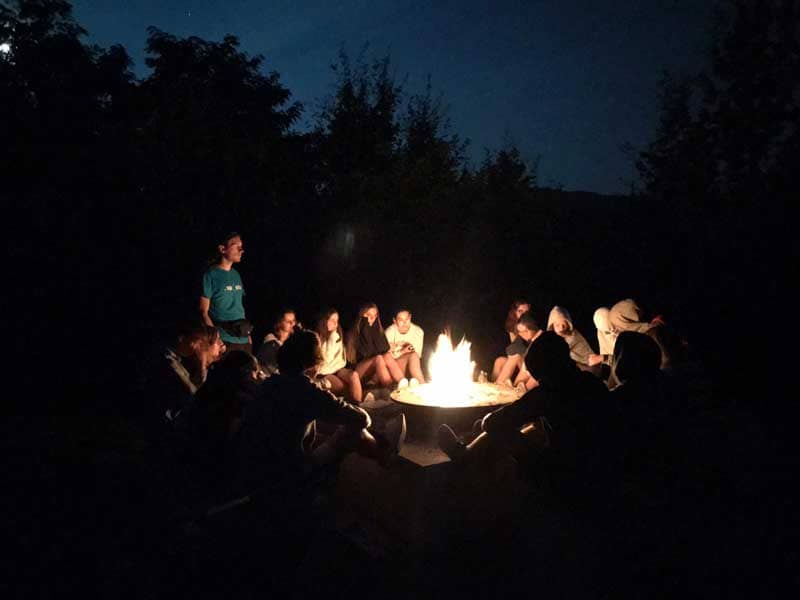 A group of youths sitting around a campfire